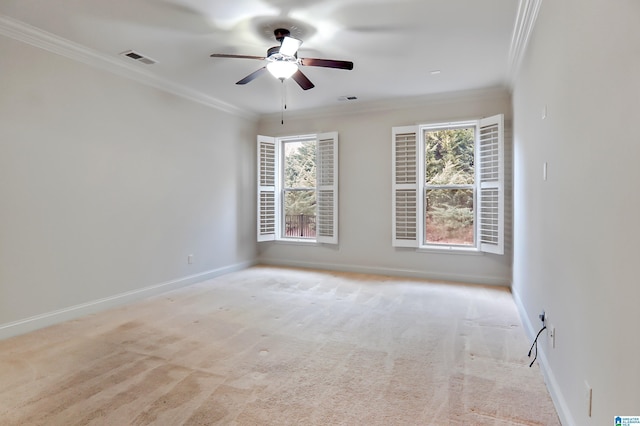 carpeted spare room featuring ornamental molding, ceiling fan, and a wealth of natural light