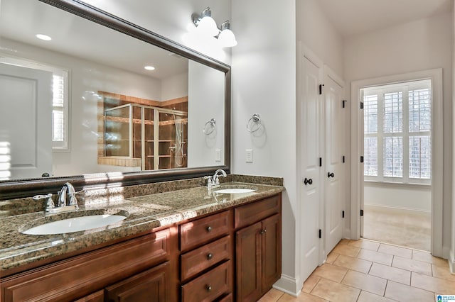 bathroom featuring tile patterned flooring, a shower with door, and vanity