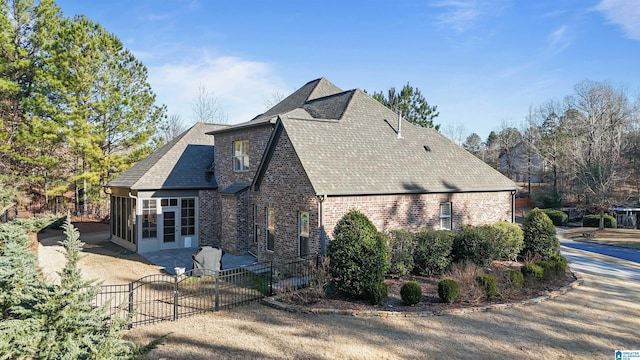 view of side of property with a patio and a sunroom