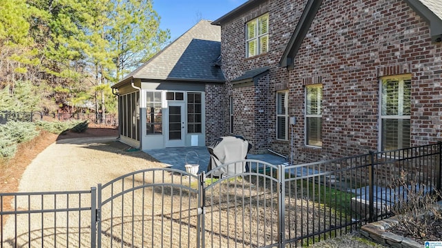 rear view of property featuring a patio and a sunroom