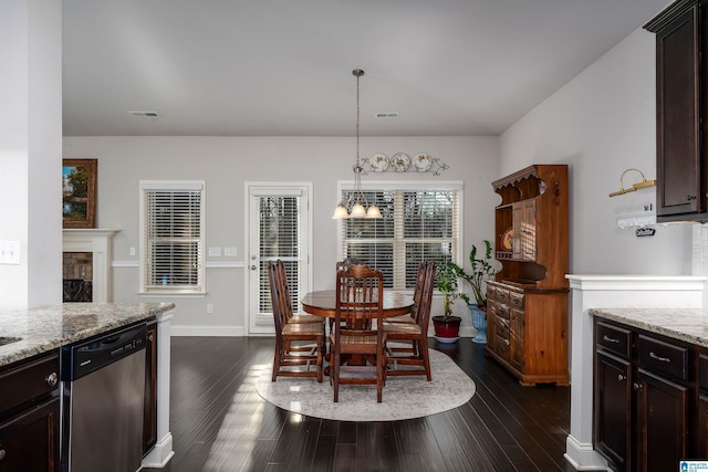 dining space with dark wood-type flooring and an inviting chandelier