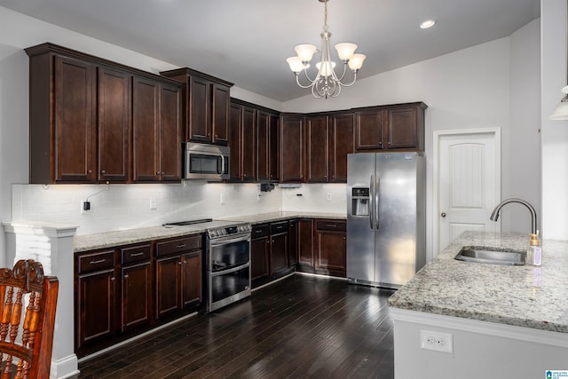 kitchen featuring light stone countertops, stainless steel appliances, a chandelier, and sink