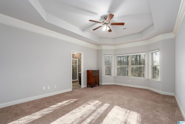 carpeted spare room featuring ceiling fan, crown molding, and a tray ceiling