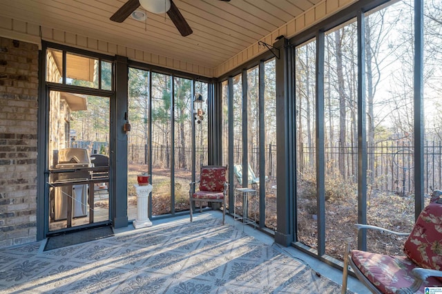 unfurnished sunroom with ceiling fan