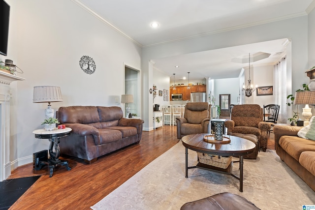 living room with a chandelier, wood-type flooring, and crown molding