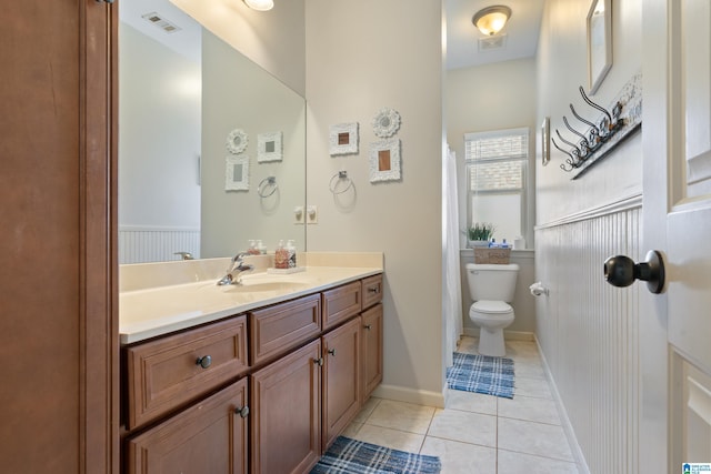 bathroom with tile patterned flooring, vanity, and toilet