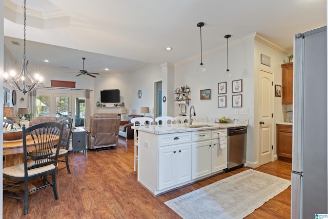 kitchen featuring sink, hanging light fixtures, white cabinets, ceiling fan with notable chandelier, and appliances with stainless steel finishes