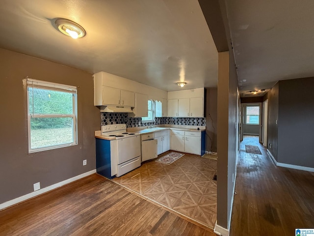 kitchen with white appliances, backsplash, sink, hardwood / wood-style flooring, and white cabinetry