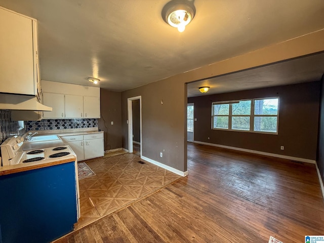 kitchen featuring tasteful backsplash, white cabinetry, sink, and hardwood / wood-style flooring