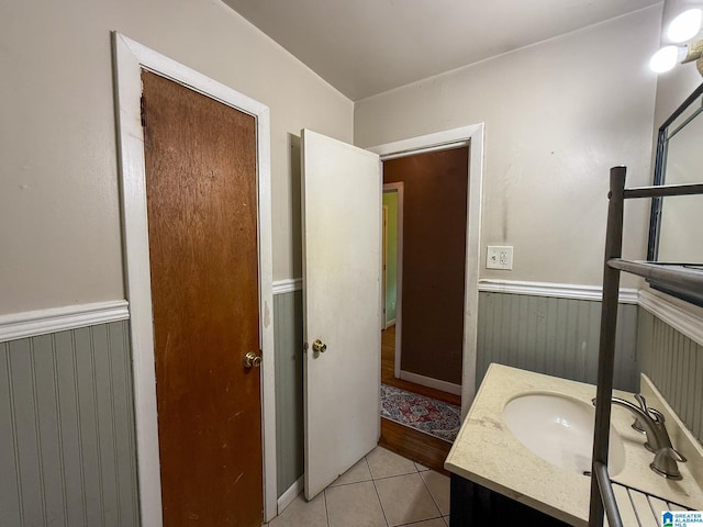 bathroom with tile patterned flooring, vanity, and wooden walls