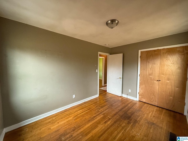 unfurnished bedroom featuring a closet and hardwood / wood-style flooring