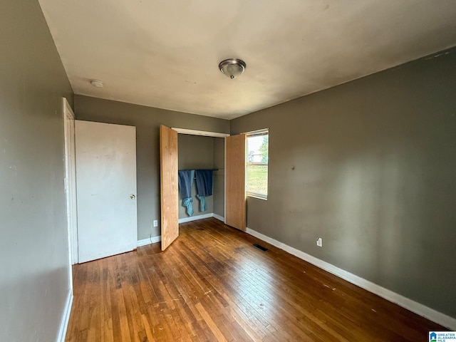 unfurnished bedroom featuring dark hardwood / wood-style floors and a closet