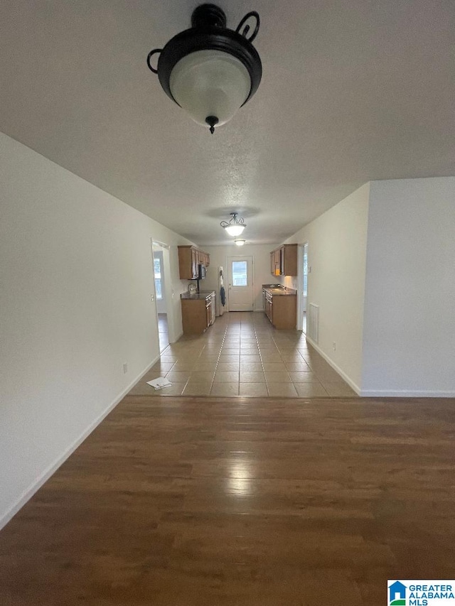 hallway featuring hardwood / wood-style flooring and a textured ceiling