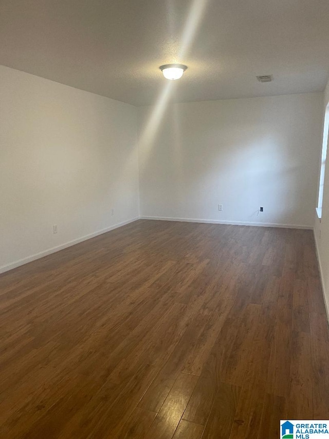 unfurnished room with dark hardwood / wood-style flooring