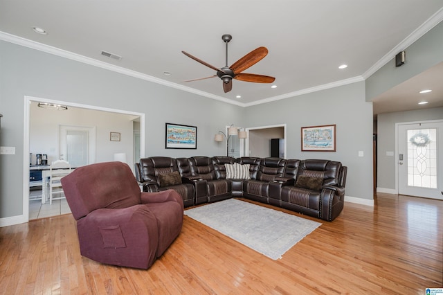 living room featuring ceiling fan, ornamental molding, and light hardwood / wood-style flooring