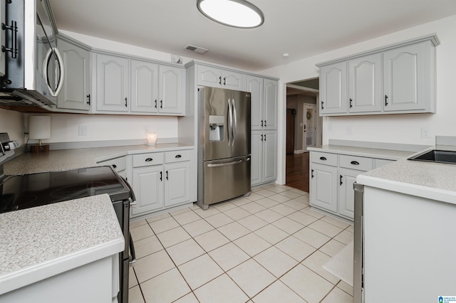 kitchen with gray cabinets, sink, light tile patterned floors, and stainless steel appliances