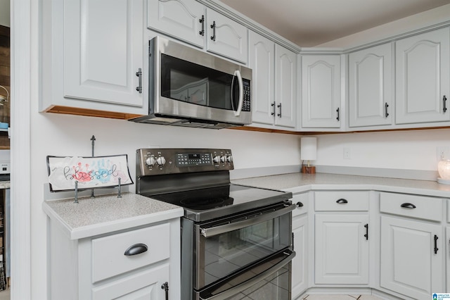 kitchen with black range with electric stovetop and white cabinetry