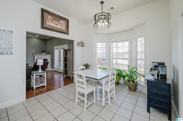 tiled dining room featuring an inviting chandelier