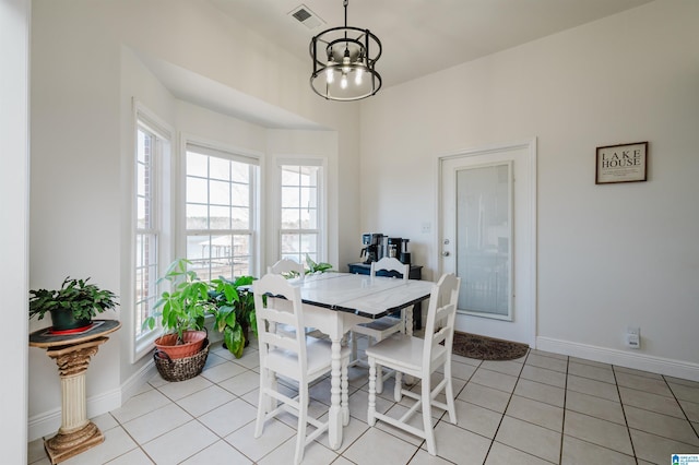 dining area featuring light tile patterned floors and an inviting chandelier