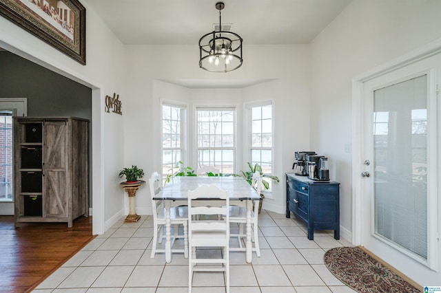 tiled dining space featuring a notable chandelier