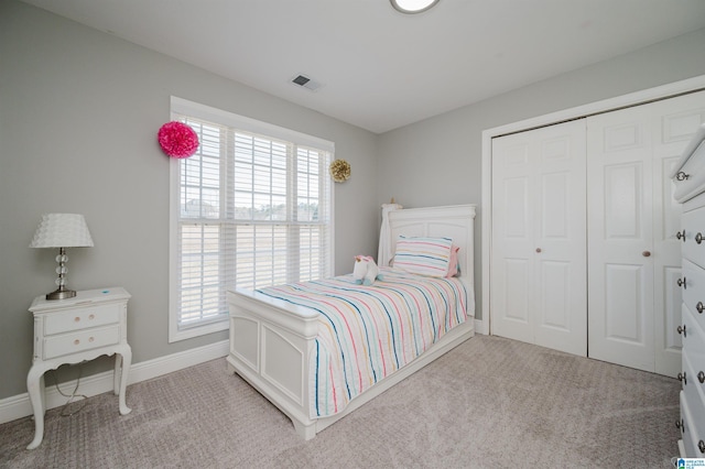 bedroom with light carpet and a closet