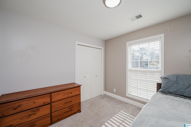 bedroom with light colored carpet and a closet