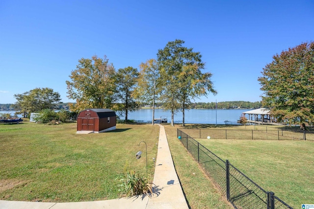 view of yard featuring a water view and a storage shed