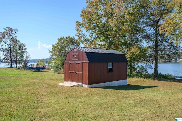 view of outbuilding with a water view and a yard