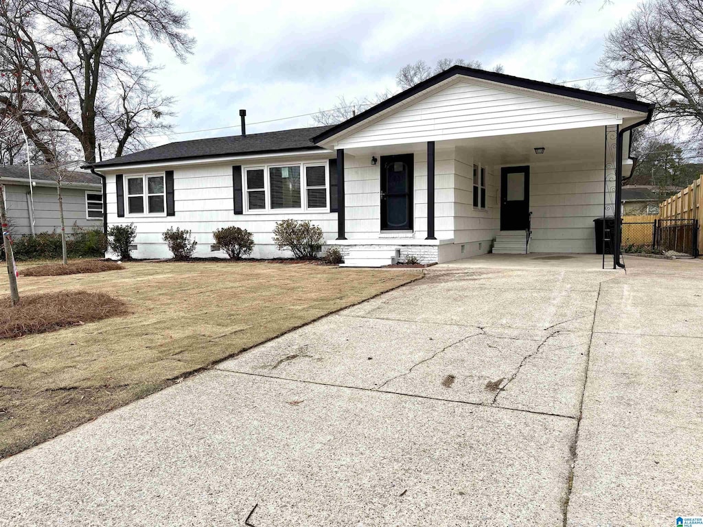 ranch-style home with a carport and a front yard