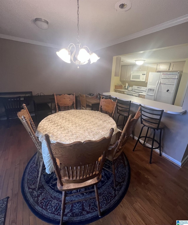 dining space with ornamental molding, dark wood-type flooring, a textured ceiling, and a notable chandelier