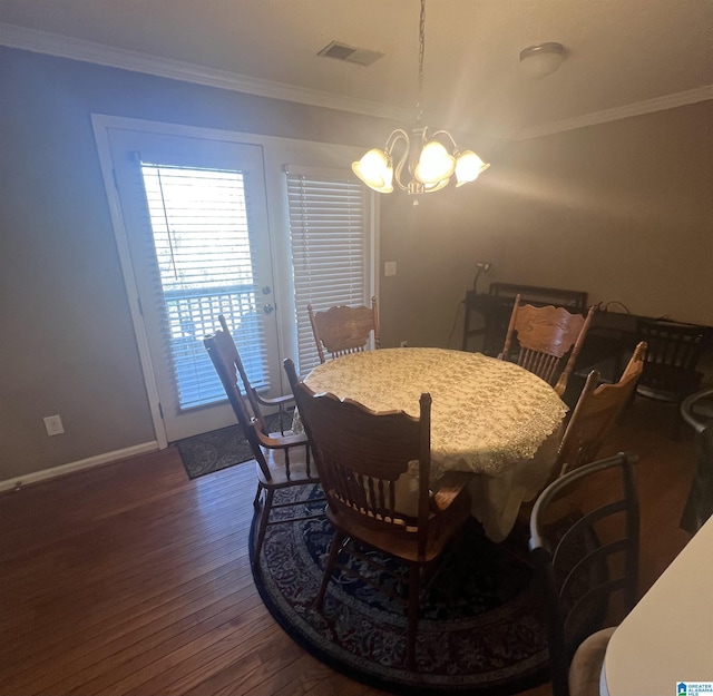 dining space featuring crown molding, dark hardwood / wood-style flooring, and a chandelier