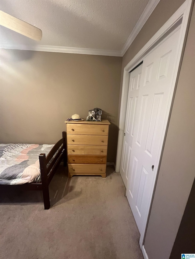 bedroom with light carpet, a closet, crown molding, and a textured ceiling