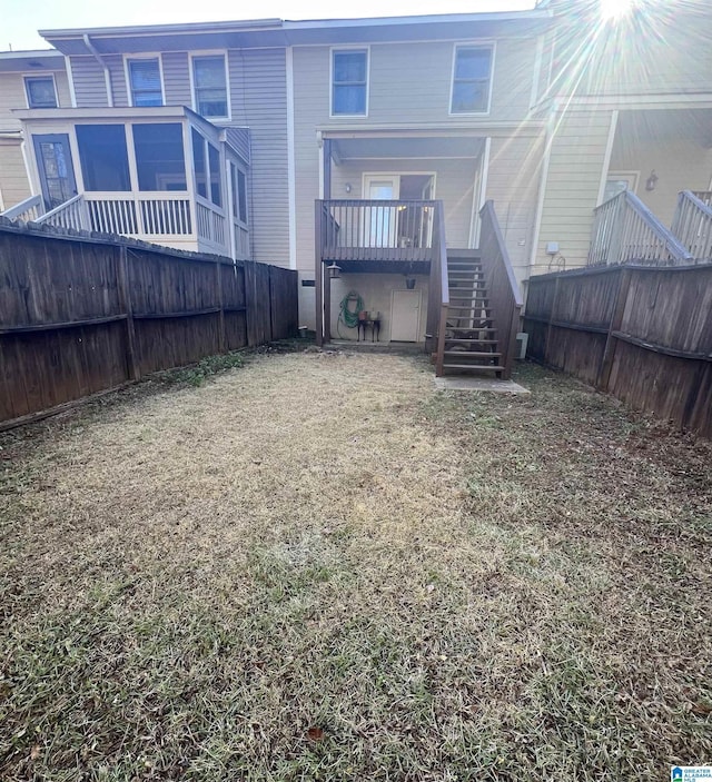 rear view of property featuring a wooden deck and a yard