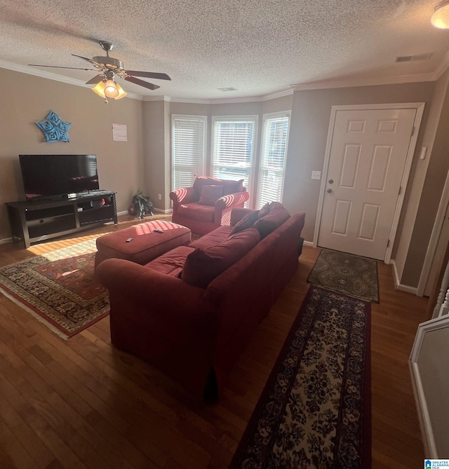 living room with ceiling fan, dark wood-type flooring, a textured ceiling, and ornamental molding