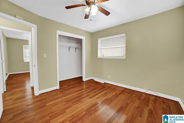 unfurnished bedroom with wood-type flooring, a closet, and ceiling fan