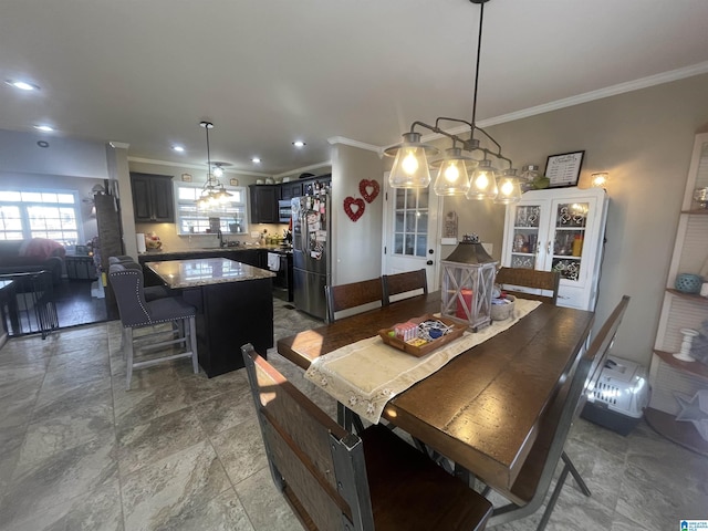 dining area with crown molding and sink