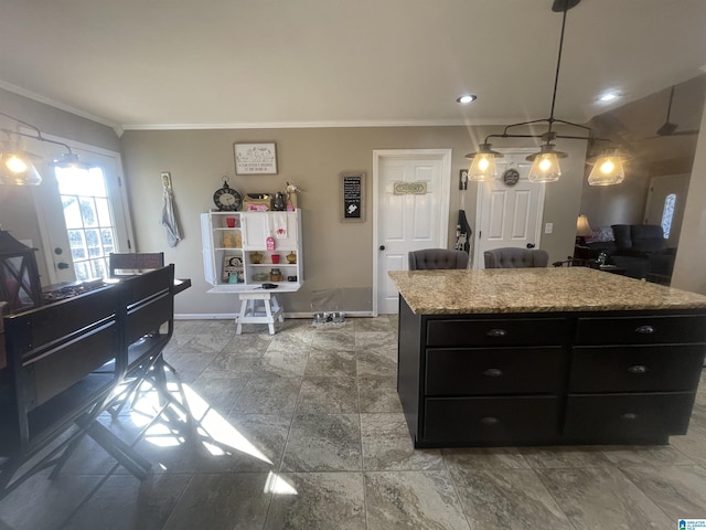 kitchen featuring decorative light fixtures, a center island, light stone countertops, and ornamental molding