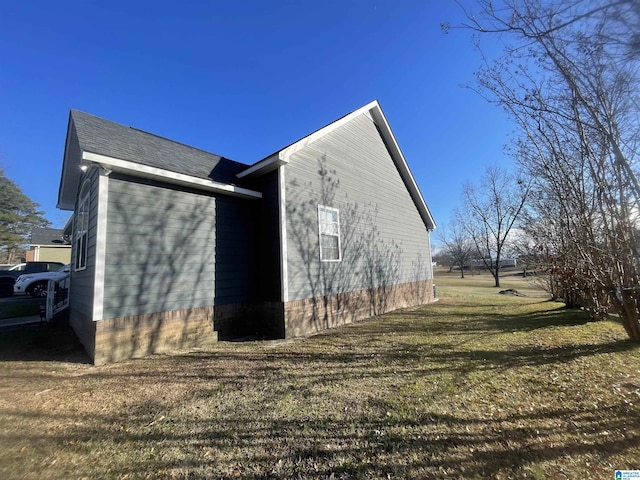 view of side of home with a yard