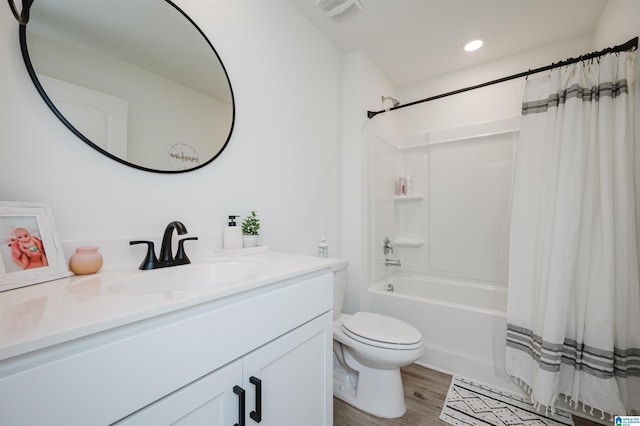 full bathroom featuring hardwood / wood-style floors, vanity, toilet, and shower / tub combo with curtain