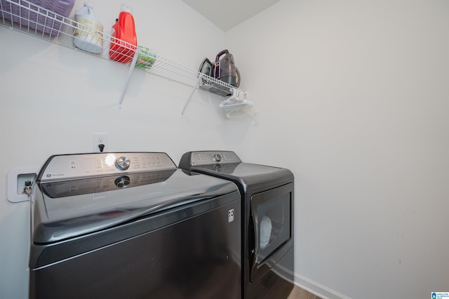 laundry room with washer and dryer and wood-type flooring