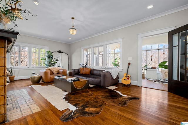 living room with hardwood / wood-style flooring, ornamental molding, and a notable chandelier