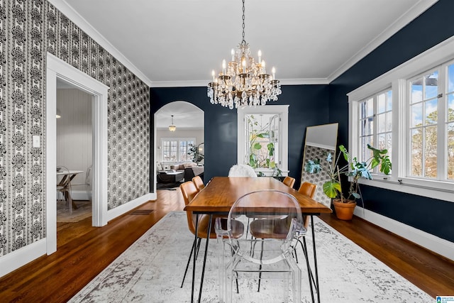 dining area with crown molding, plenty of natural light, dark hardwood / wood-style floors, and a notable chandelier