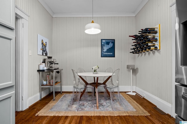 dining space with crown molding and dark hardwood / wood-style flooring