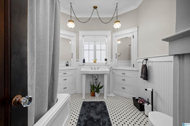 bathroom with toilet, shower / bathtub combination with curtain, and ornamental molding