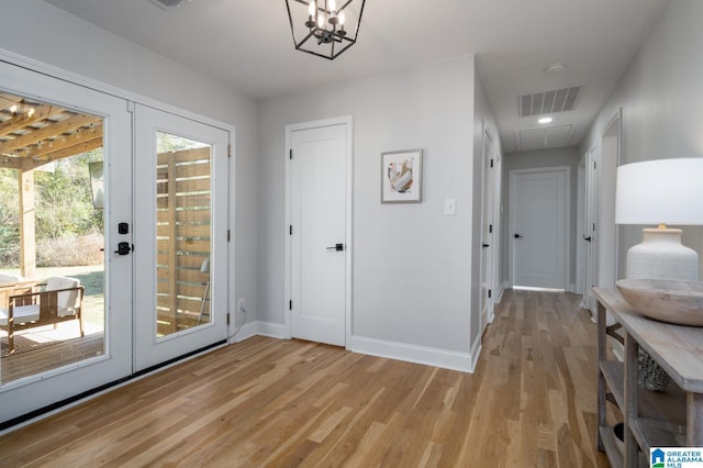 interior space with a notable chandelier and light wood-type flooring