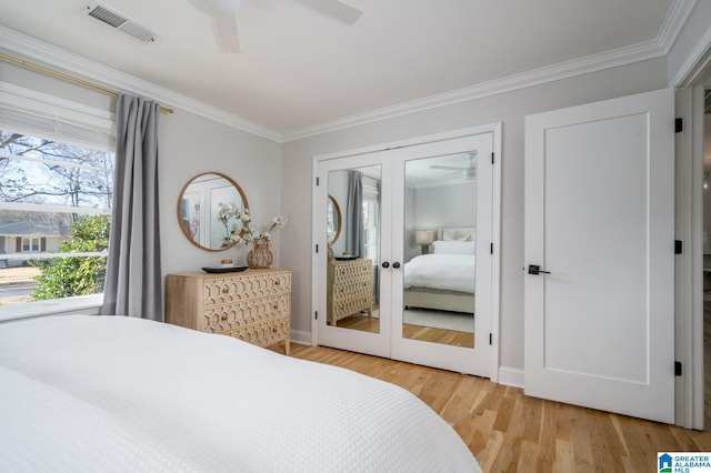 bedroom featuring hardwood / wood-style floors, ceiling fan, ornamental molding, and french doors