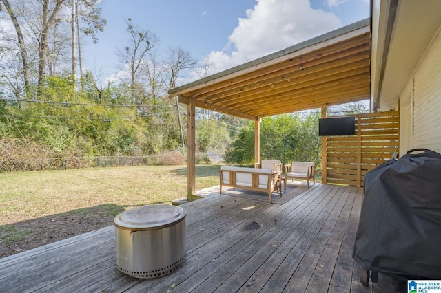 wooden deck featuring a grill and a yard