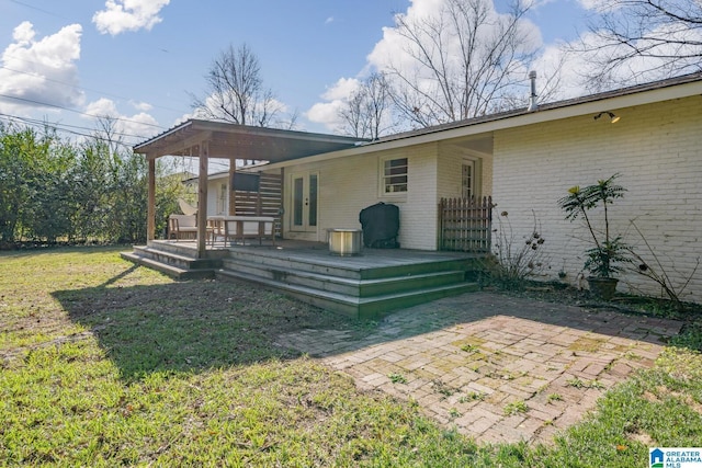 back of property with a patio area and a lawn