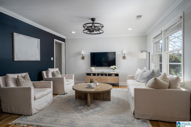 living room with crown molding, a notable chandelier, and hardwood / wood-style flooring