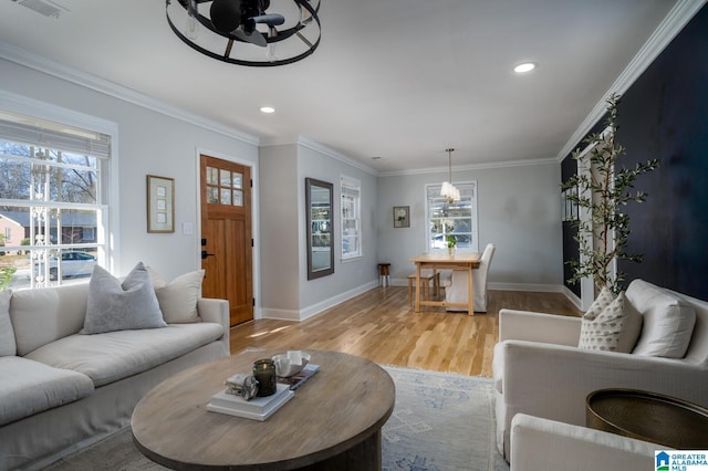 living room with a wealth of natural light, ceiling fan, light hardwood / wood-style floors, and ornamental molding